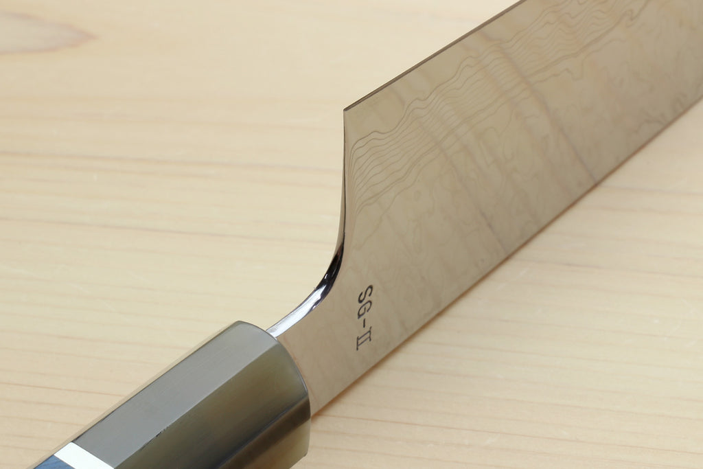Kiritsuke chef knife heel close-up with etched markings and ocean blue handle