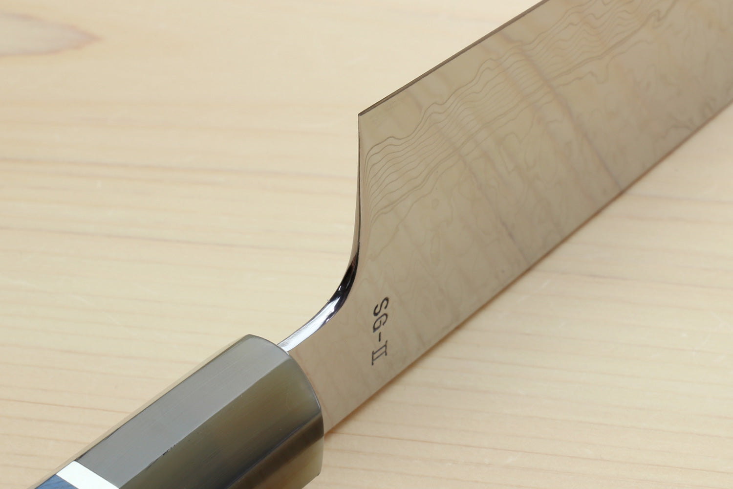 Kiritsuke chef knife heel close-up with etched markings and ocean blue handle
