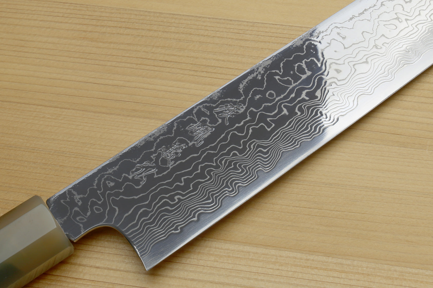Utility-Kiritsuke chef knife blade closeup with dark damascus pattern