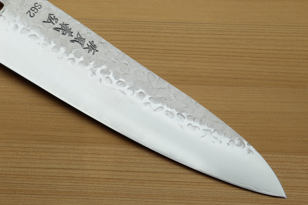 Hammered stainless gyuto knife blade with textured pattern and tapered edge