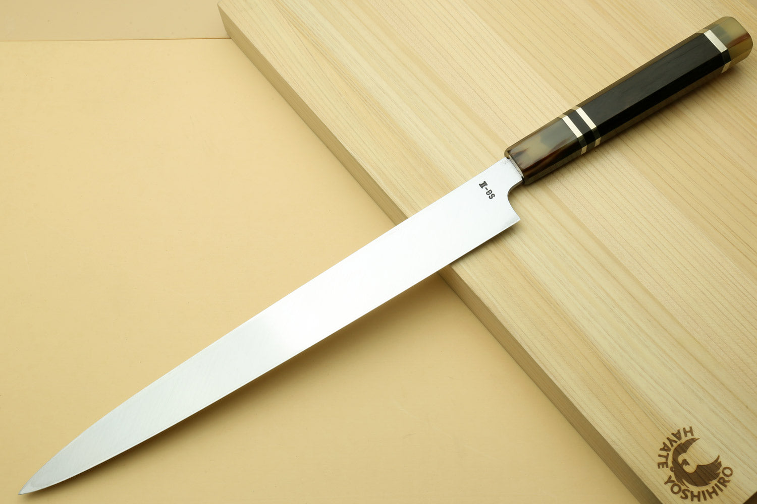 Yanagi sashimi knife with mirror-polished blade and dark triple-ring ebony handle