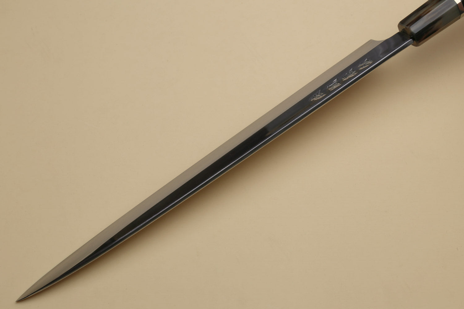 Long yanagi sashimi knife with mirror-polished blade and dark triple-ring ebony handle