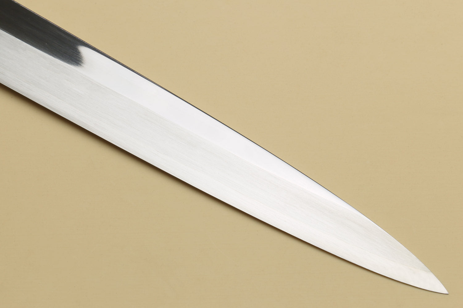 Mirror-polished yanagi sashimi knife blade with pointed tip and smooth edge