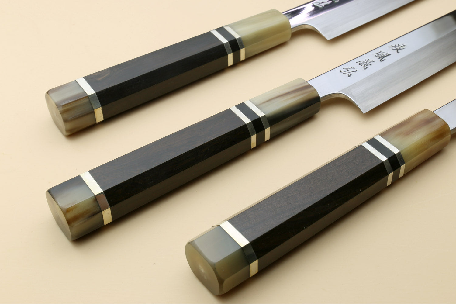 Yanagi kiritsuke knife with mirror-polished blade and dark triple-ring ebony handle