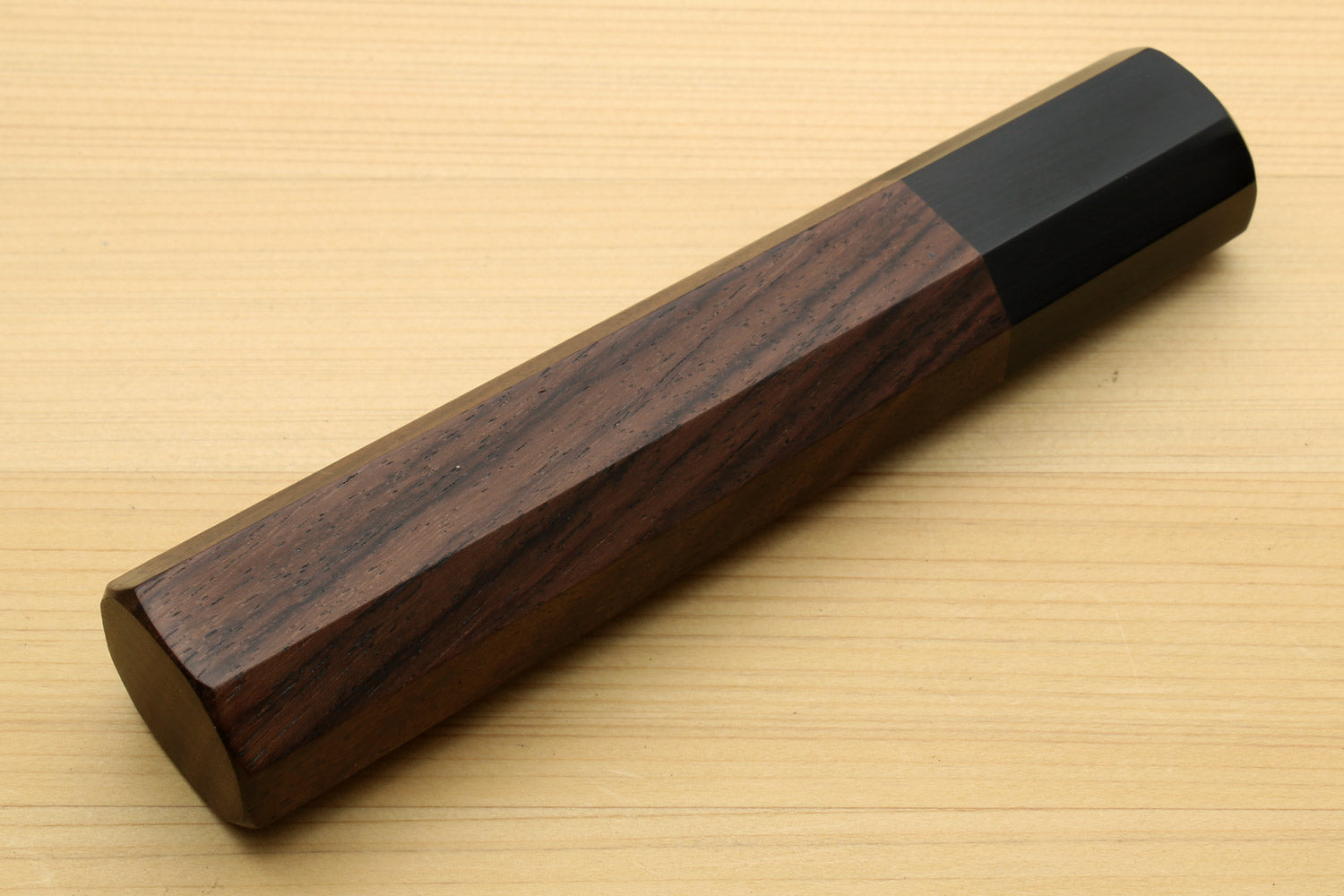 Chef knife handle with rosewood body and ebony bolster, end-to-side close-up