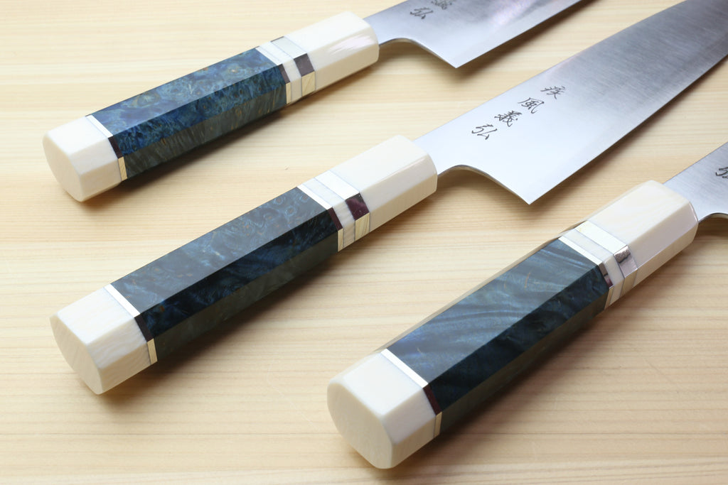 Three gyuto chef knives with ocean blue handles and ivory bolsters, stainless blades