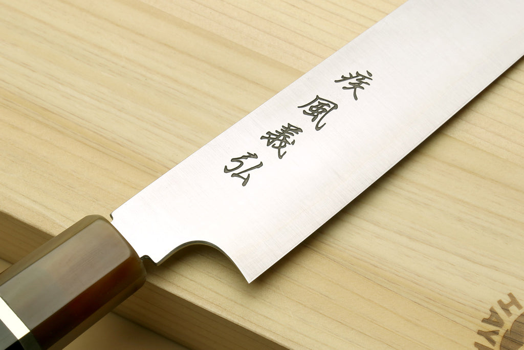 Sujihiki-kiritsuke knife close-up of engraved blade and dark wooden handle