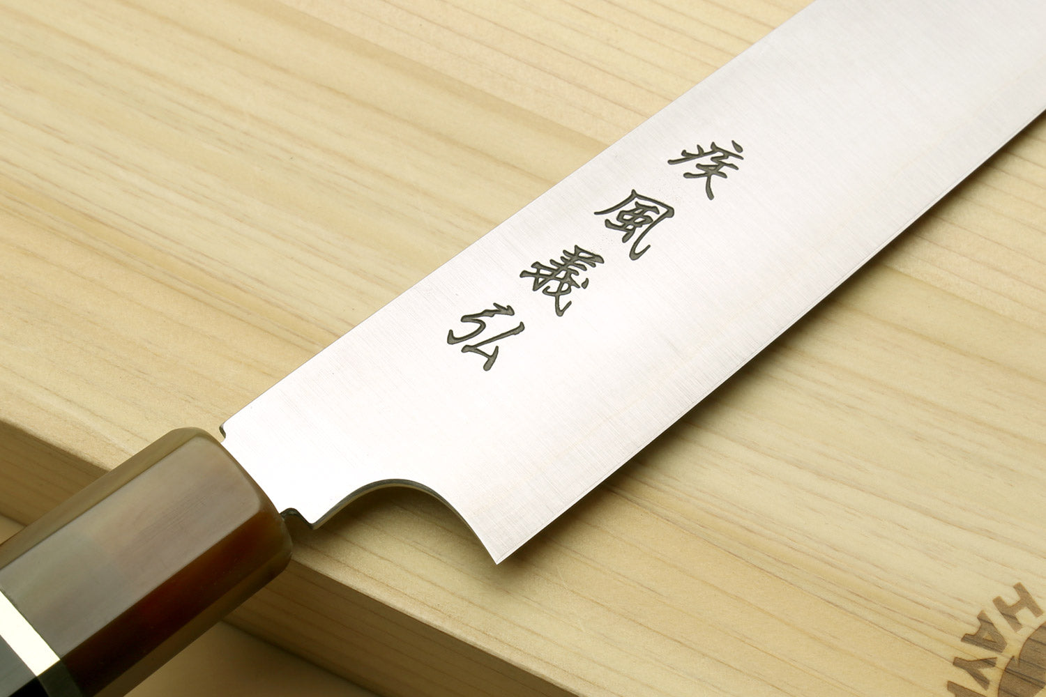 Sujihiki-kiritsuke knife close-up of engraved blade and dark wooden handle