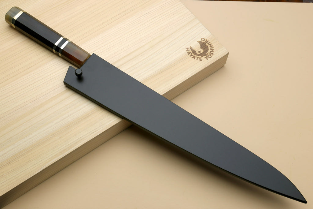 Sujihiki-kiritsuke slicer knife with stainless blade and dark handle on wooden base