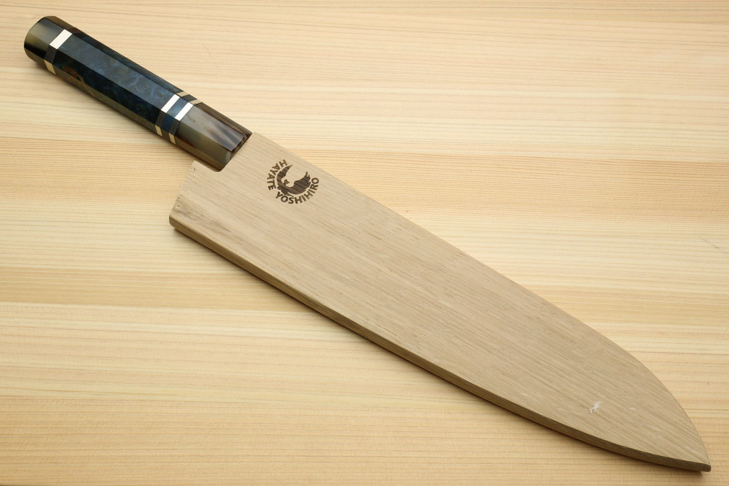 Gyuto chef knife with ocean blue handle and damascus blade on wooden board