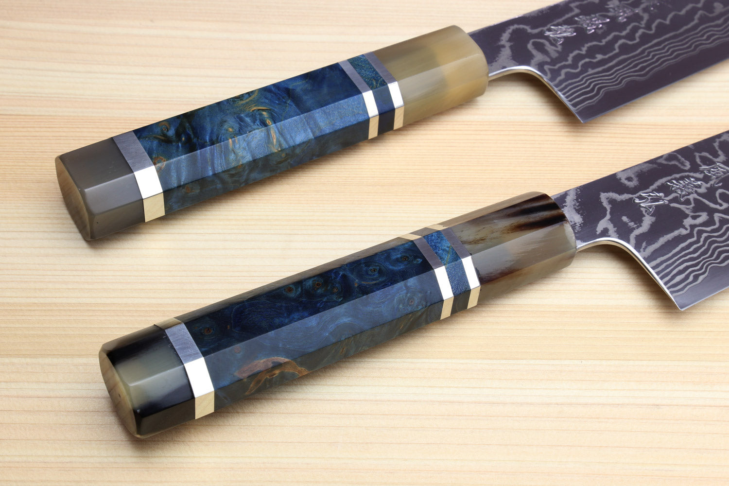Two kiritsuke chefs knives with damascus blades and ocean blue handles