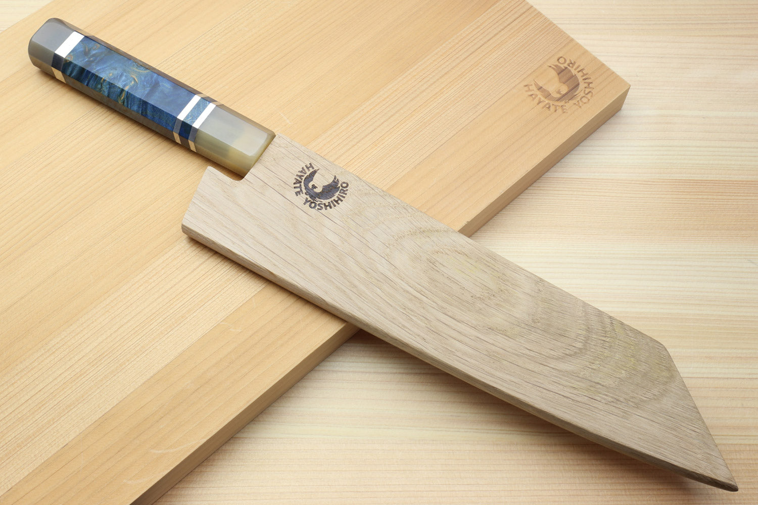Kiritsuke chefs knife with damascus blade and ocean blue handle on wood blocks