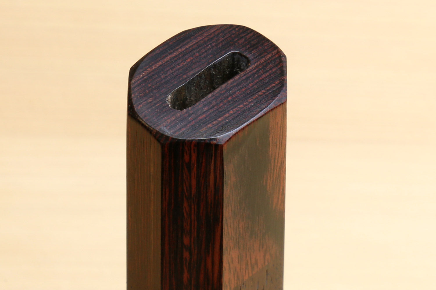 Rosewood handle end with dark mahogany bolster and oval lanyard hole
