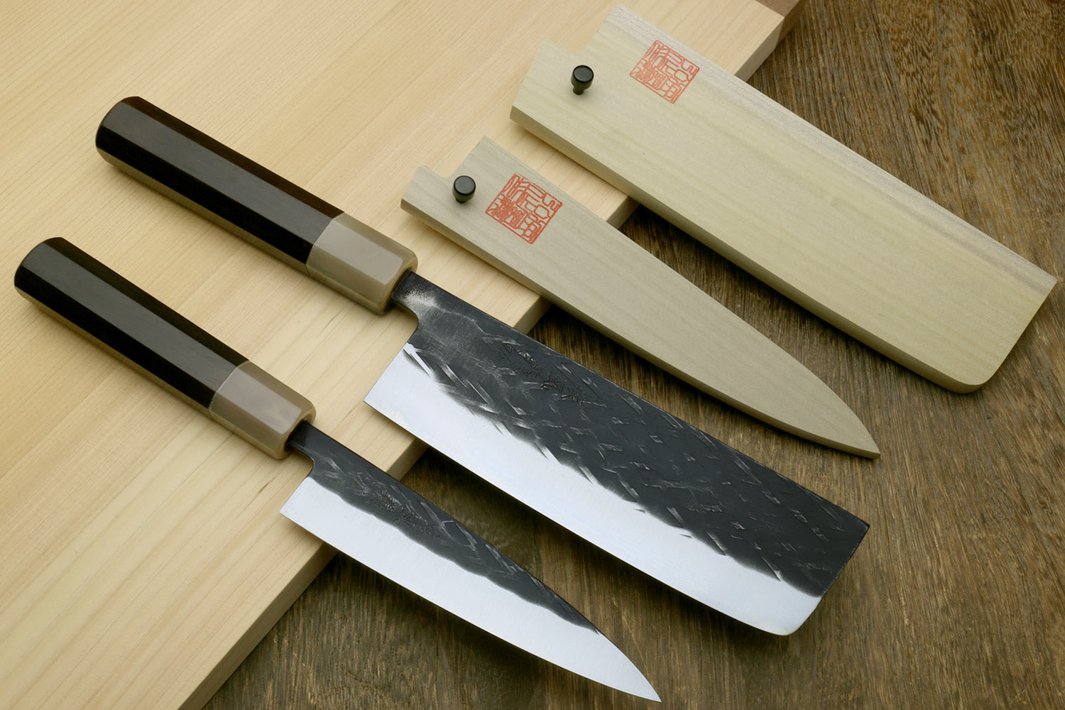 2pc knife set with nakiri and petty, black handles, and matching wooden covers