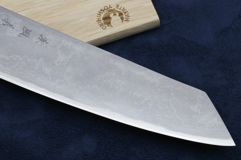 Silver damascus knife blade with white handle and stamped logo on wood
