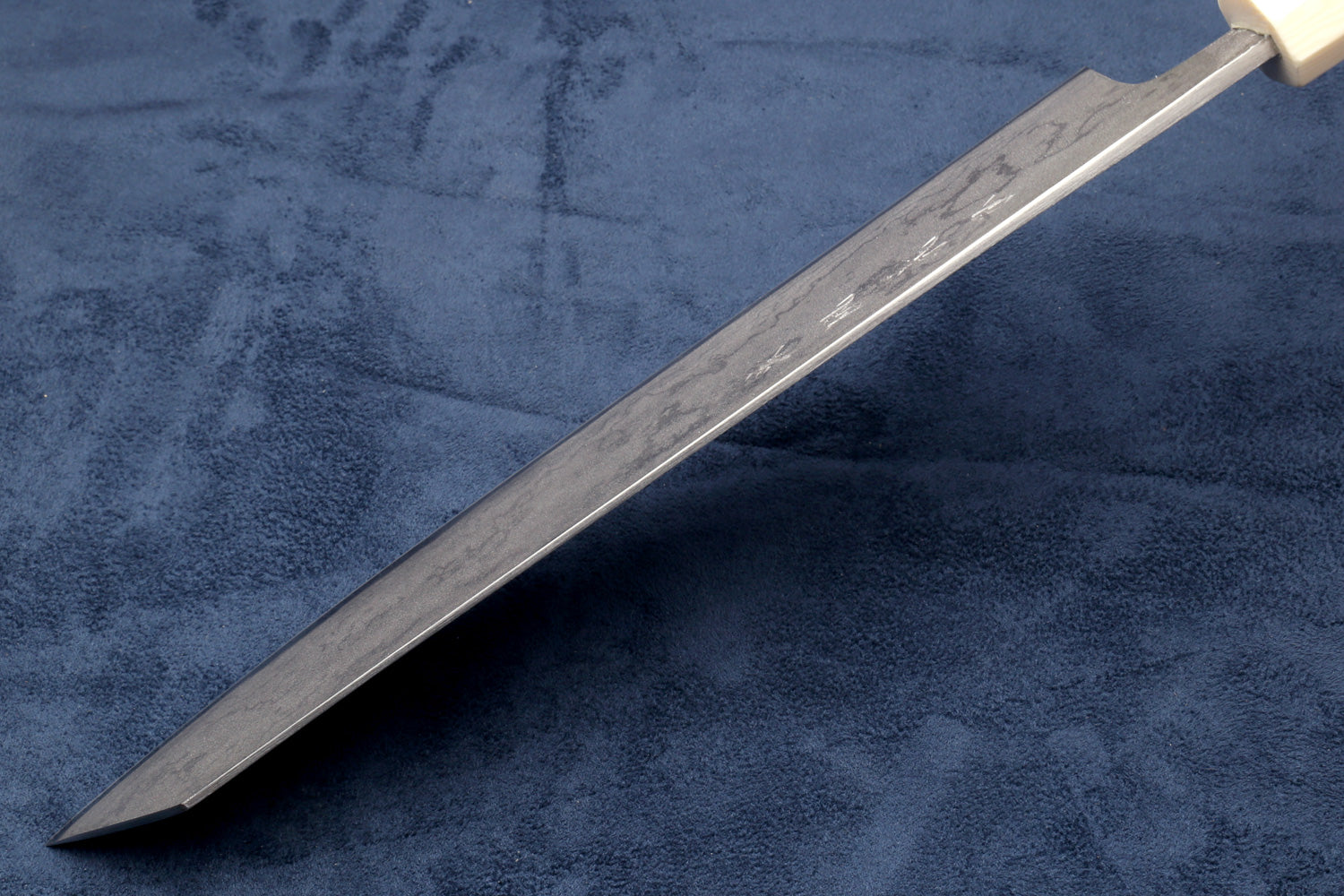 Damascus Japanese chef knife with silver blade and white handle along spine