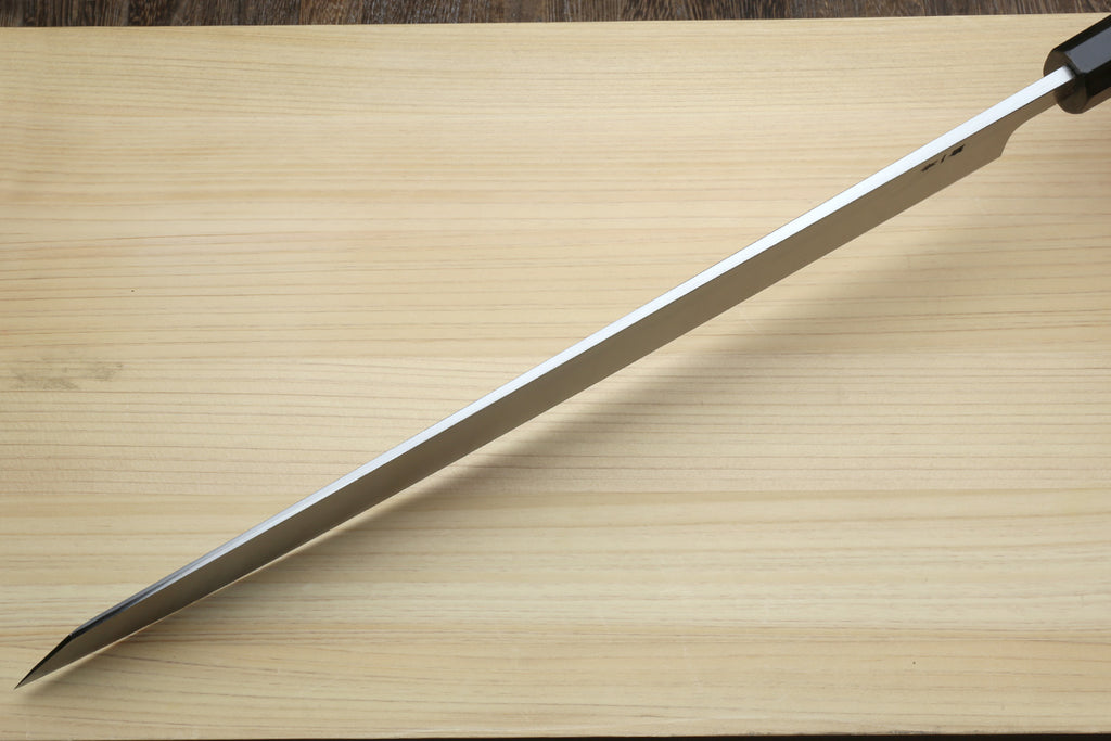 Yanagi kiritsuke blade close-up with pointed tip and etched steel finish