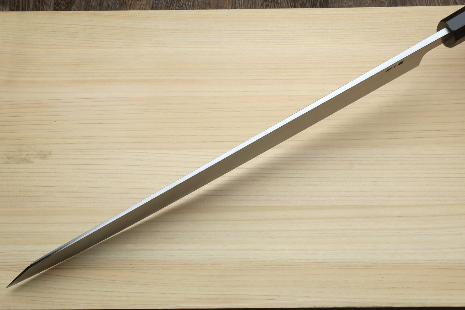 Yanagi kiritsuke blade close-up with pointed tip and etched steel finish