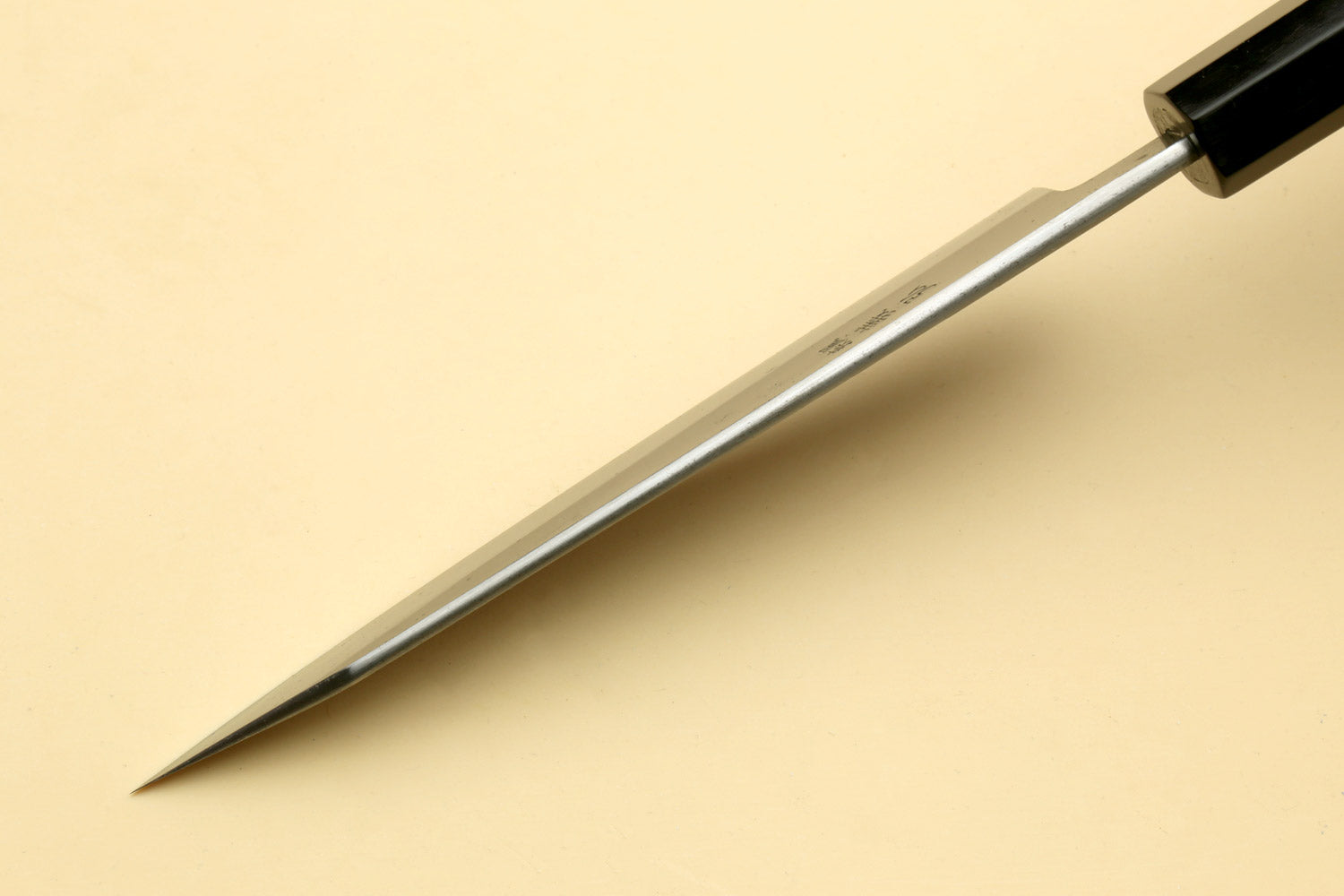Petty-kiritsuke knife with long edge and ebony handle, tip facing down
