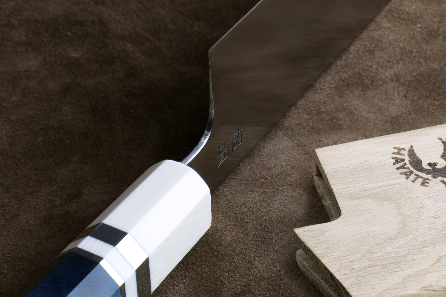 Gyuto knife handle close-up: octagonal ivory bolster and blue-gray grip, tang mark
