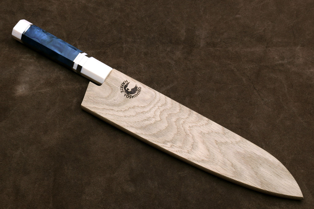 Gyuto chef knife with stainless blade, ivory bolster, octagonal blue handle on wooden block