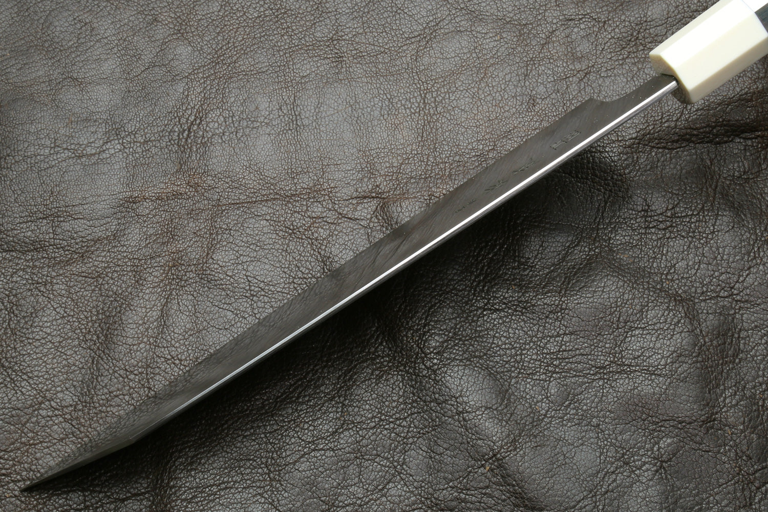 Kiritsuke knife with stainless steel blade and ivory bolster, angled view