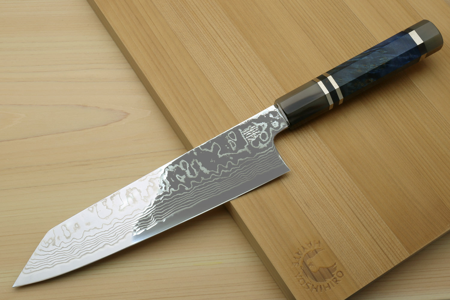 Damascus kiritsuke chef knife with blue octagonal handle, shown in side view