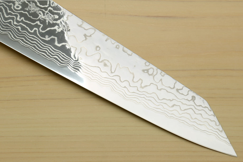 Kiritsuke chef knife tip close-up with etched damascus wavy pattern