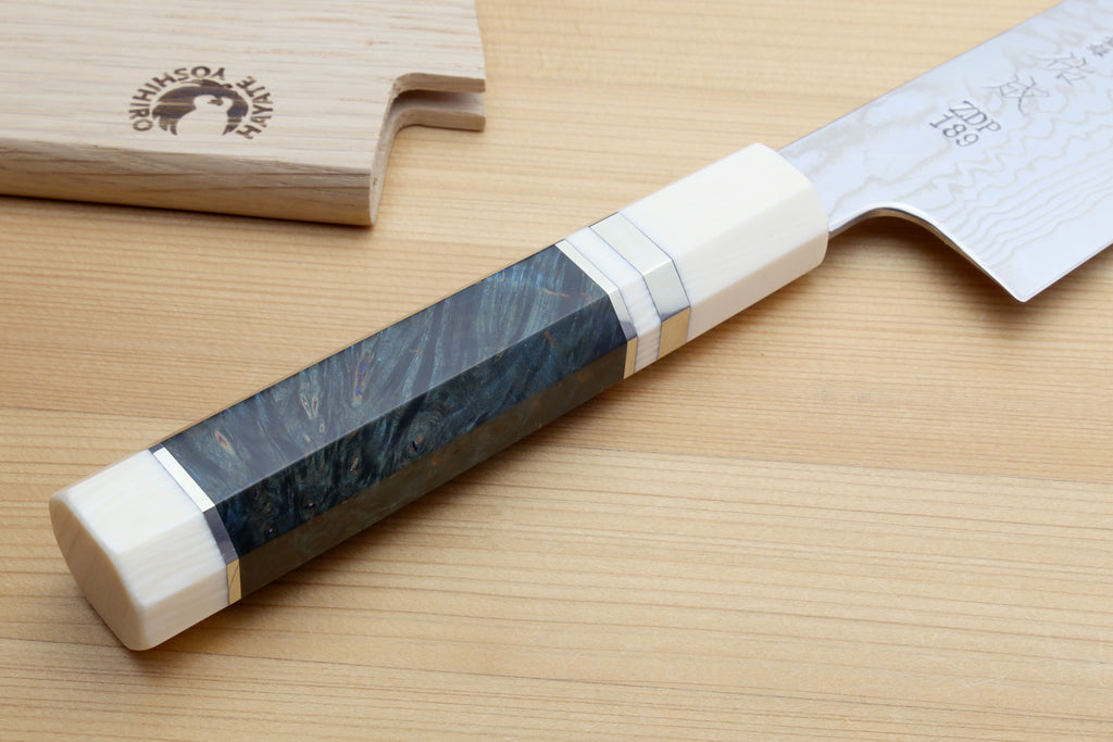 Kiritsuke chef knife with dark octagonal handle, ivory bolster, and Damascus blade
