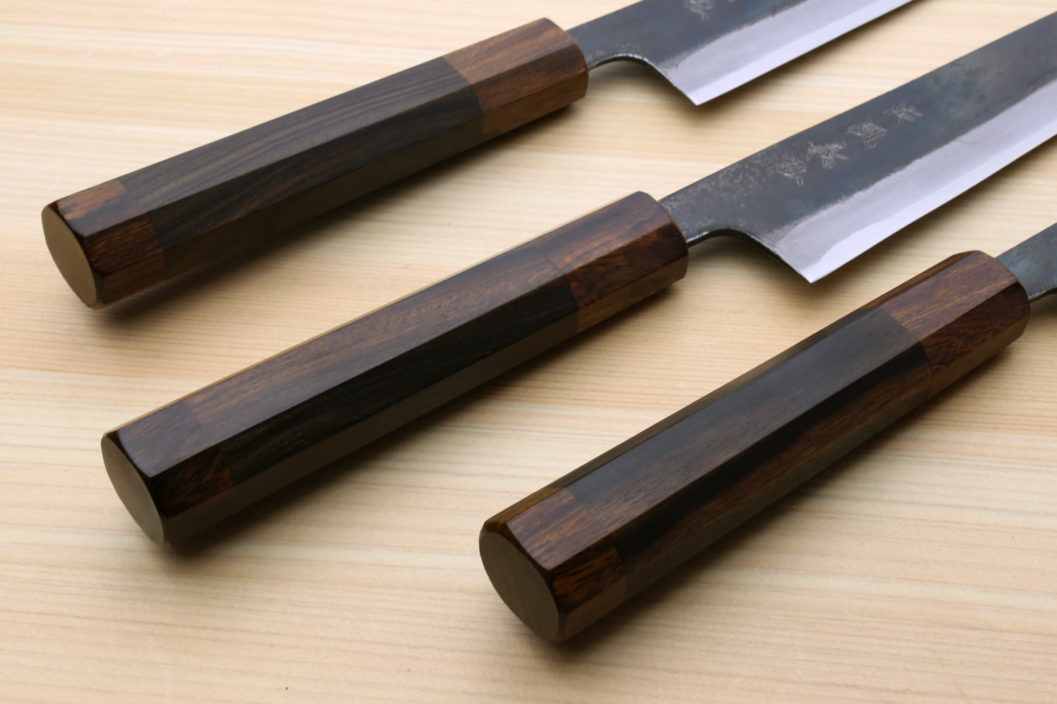 Three Japanese utility knives with ebony handles and kurouchi blades