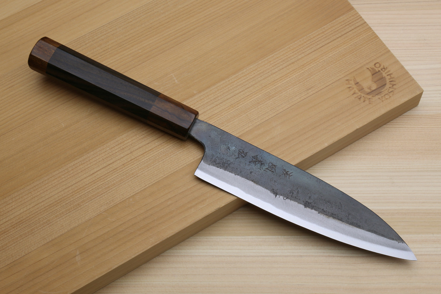 Petty utility knife with dark ebony handle and blue-gray kurouchi steel blade