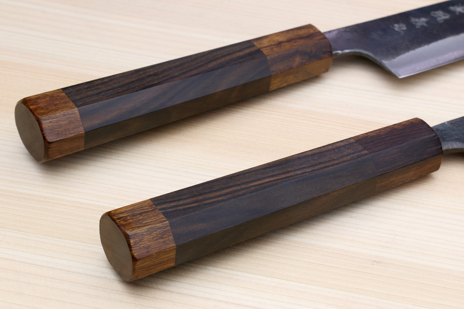 Utility knife with dark metal blade and wood handle, close-up view