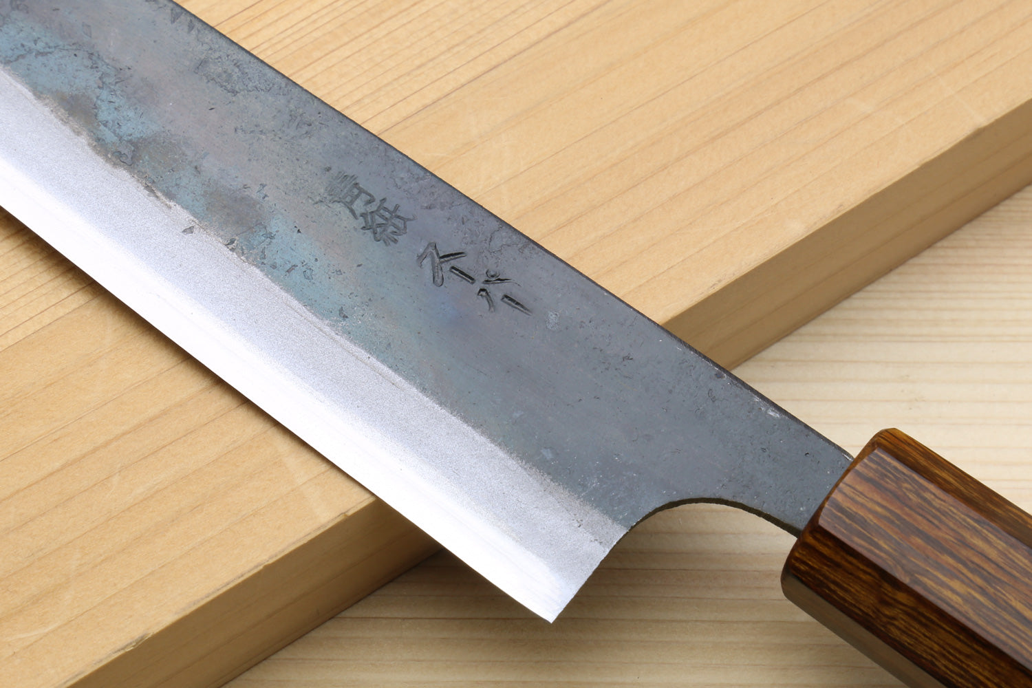 Utility knife blade edge close-up with engraved markings and curved tip
