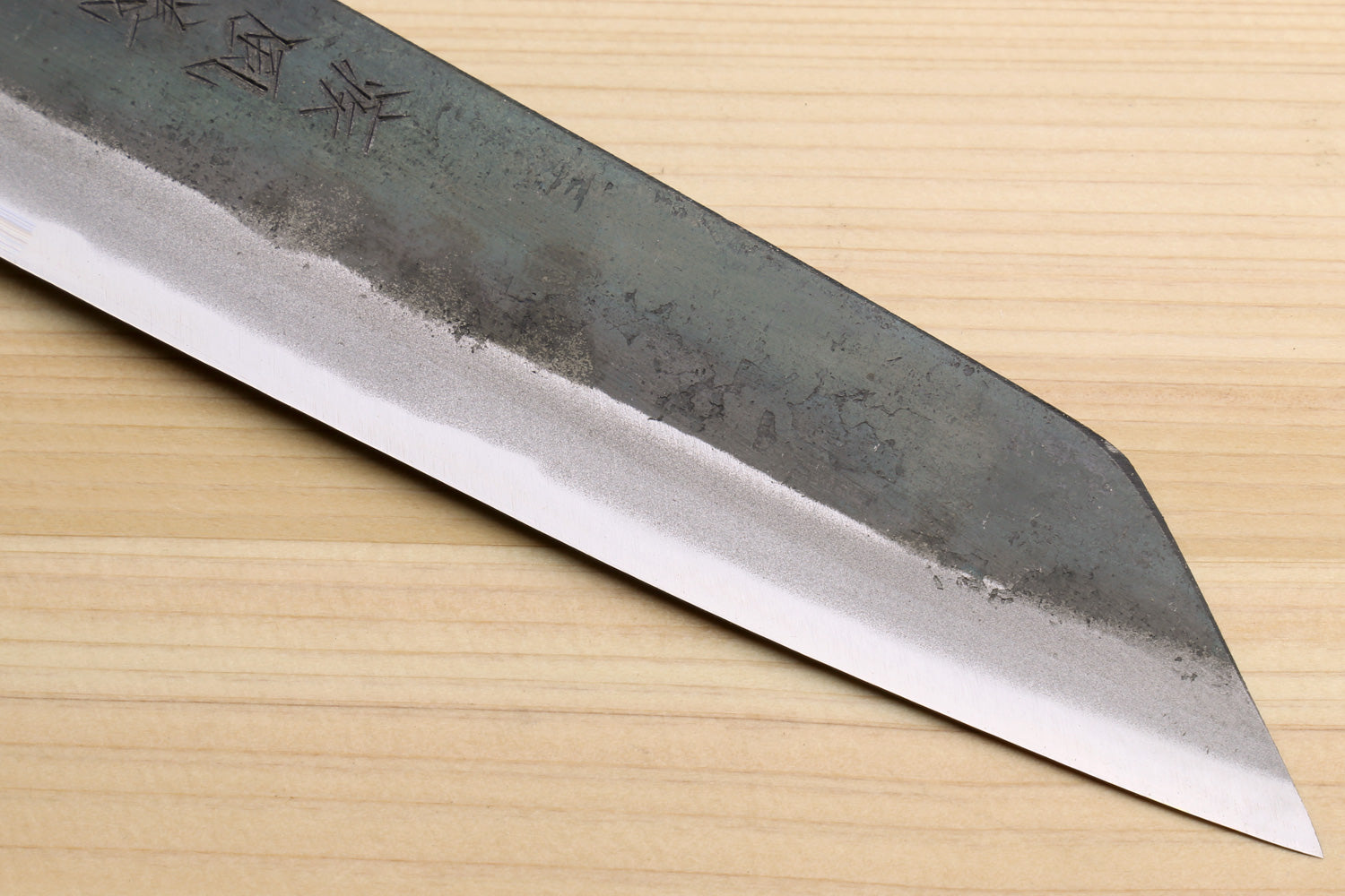 Utility knife blade close-up with shiny edge and dark kurouchi surface