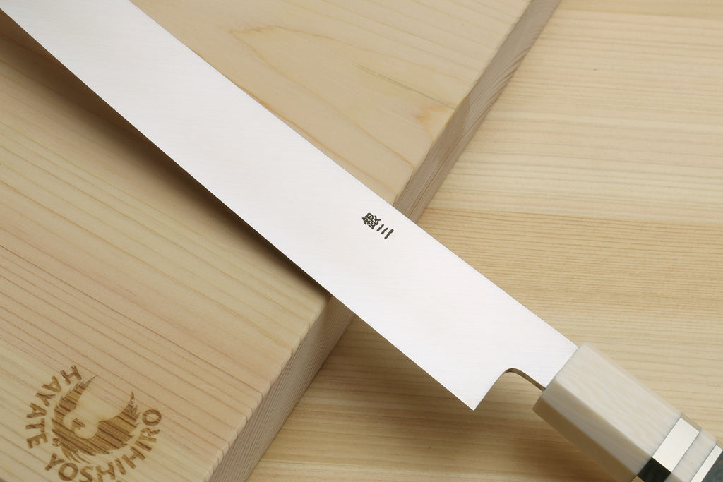 Sakimaru sushi slicer knife close-up of mirror-polished blade and ivory bolster, dark handle