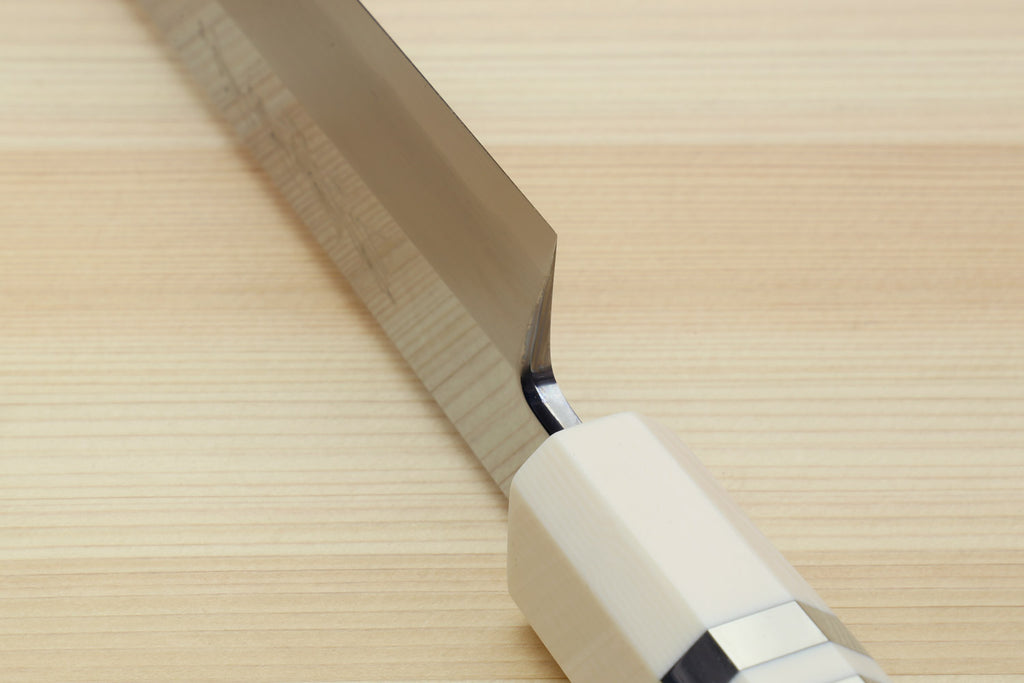 Sakimaru sushi slicer knife tip close-up with mirror-polished steel blade and ivory bolster