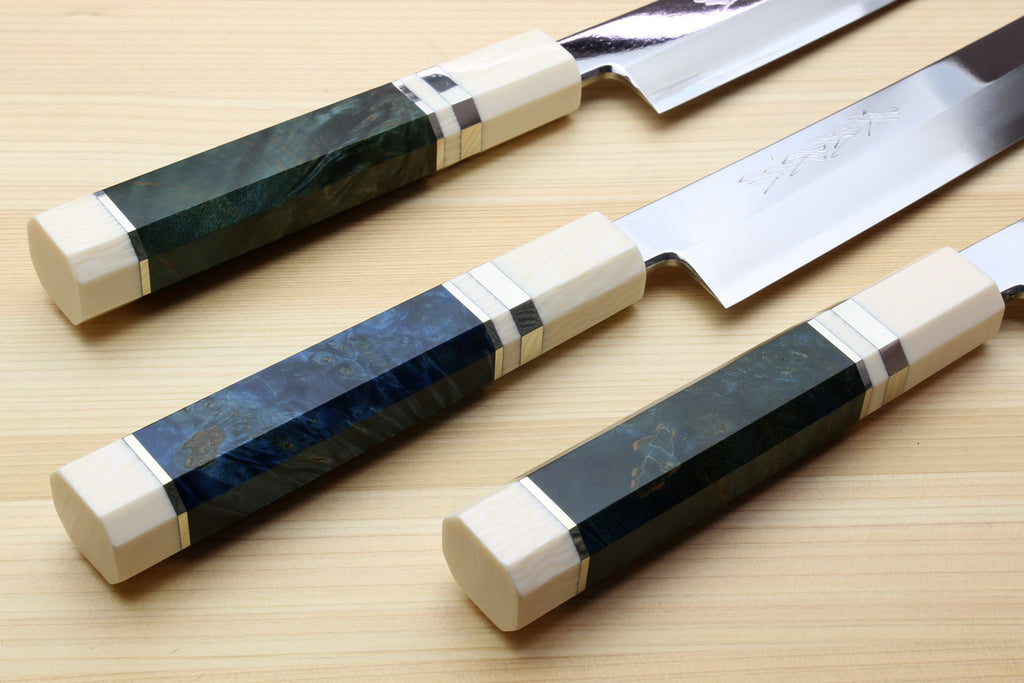 Sakimaru sushi slicer knives with blue-dark handles and ivory bolsters, mirror-polished blades