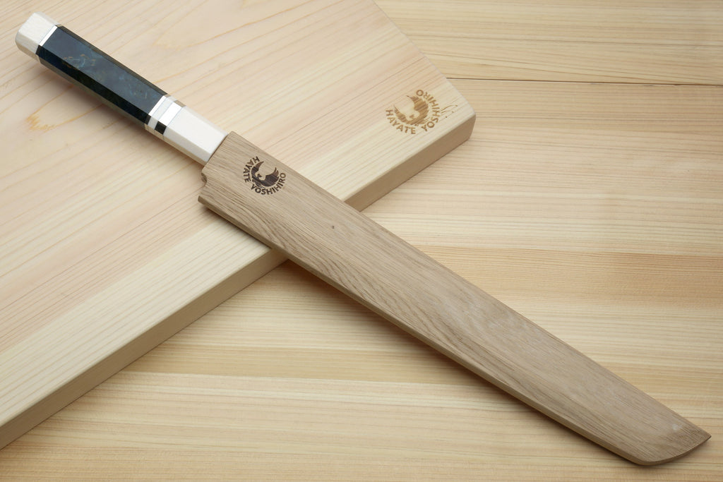 Sakimaru sushi slicer knife with mirror-polished blade and dark blue handle, stored in saya