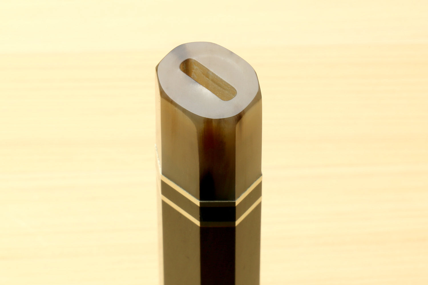 Chef knife handle end with horn bolster and triple ring stripes, thumb slot visible