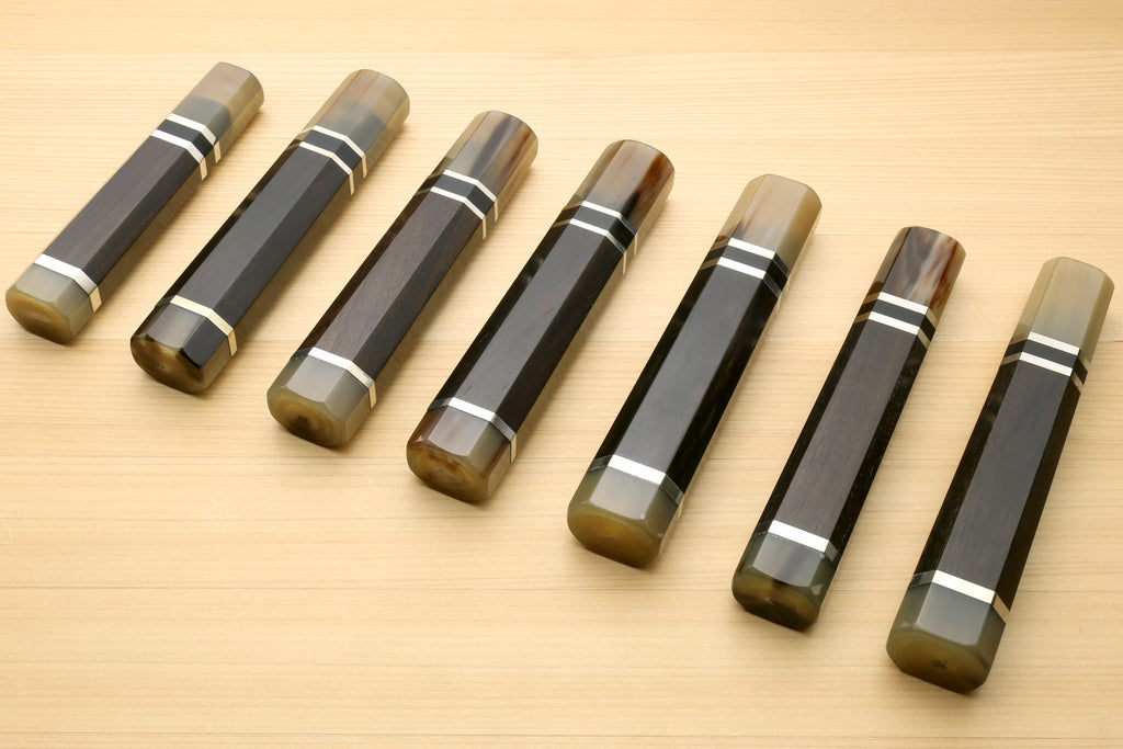 Chef knife handles arranged diagonally, horn bolster ends and triple ring stripe bands