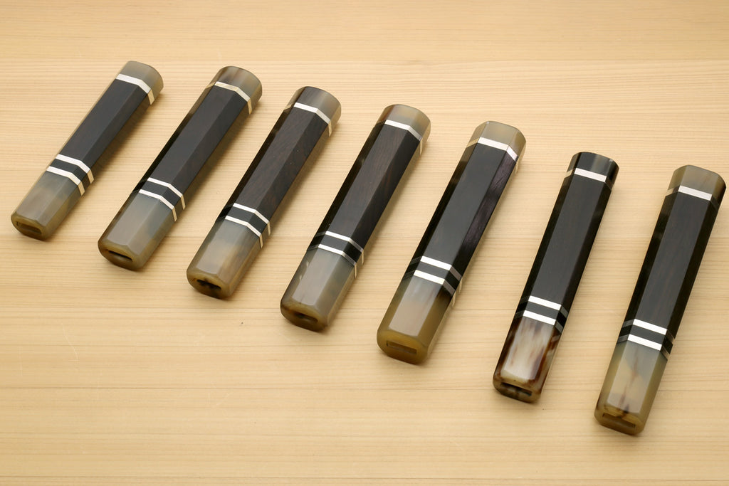 Chef knife handle set showing multiple sizes, horn bolster ends and triple ring stripes