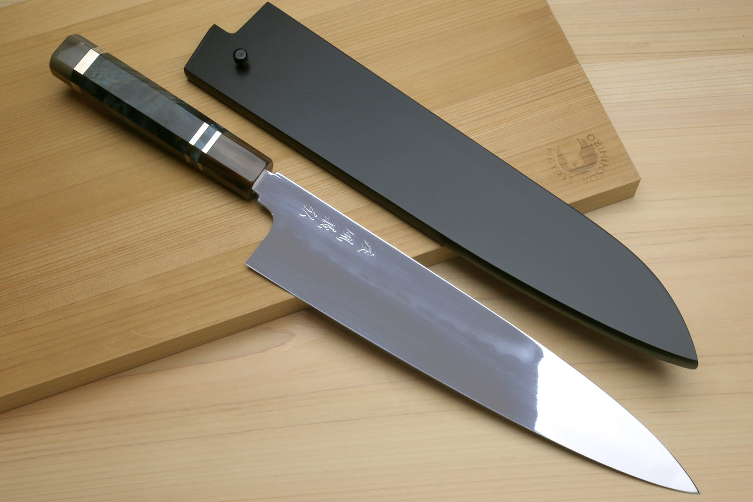 Gyuto chef knife with dark wooden handle and polished steel blade
