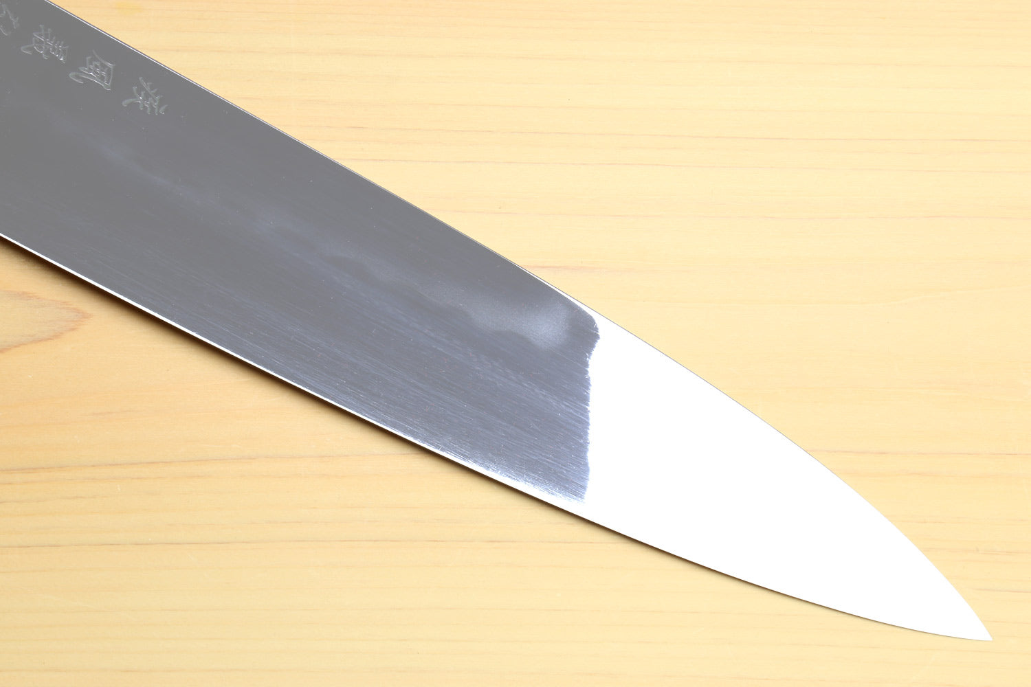 Gyuto chef knife close-up of polished blade tip and cutting edge
