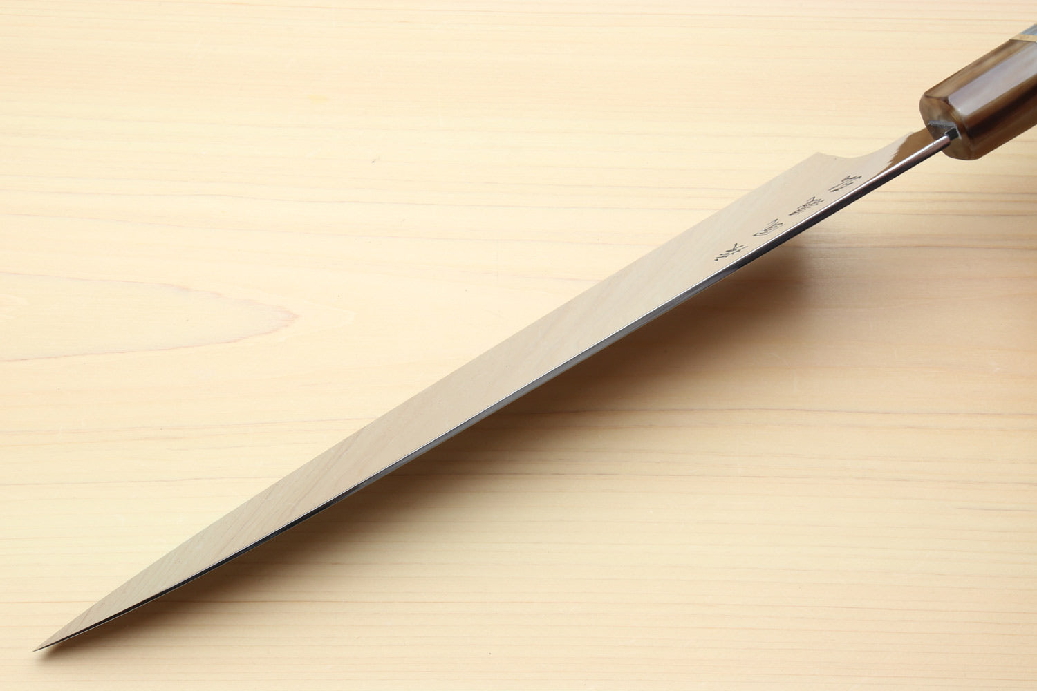 Gyuto chef knife side view with polished blade edge and dark wooden handle