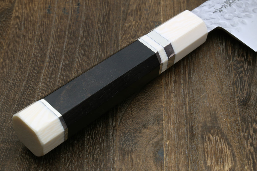 Gyuto chef's knife handle close-up with dark grip and off-white bolster, no blade sheath