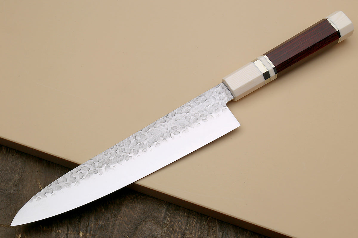 Chef's gyuto knife angled view: hammered stainless blade, rosewood handle, ivory bolster