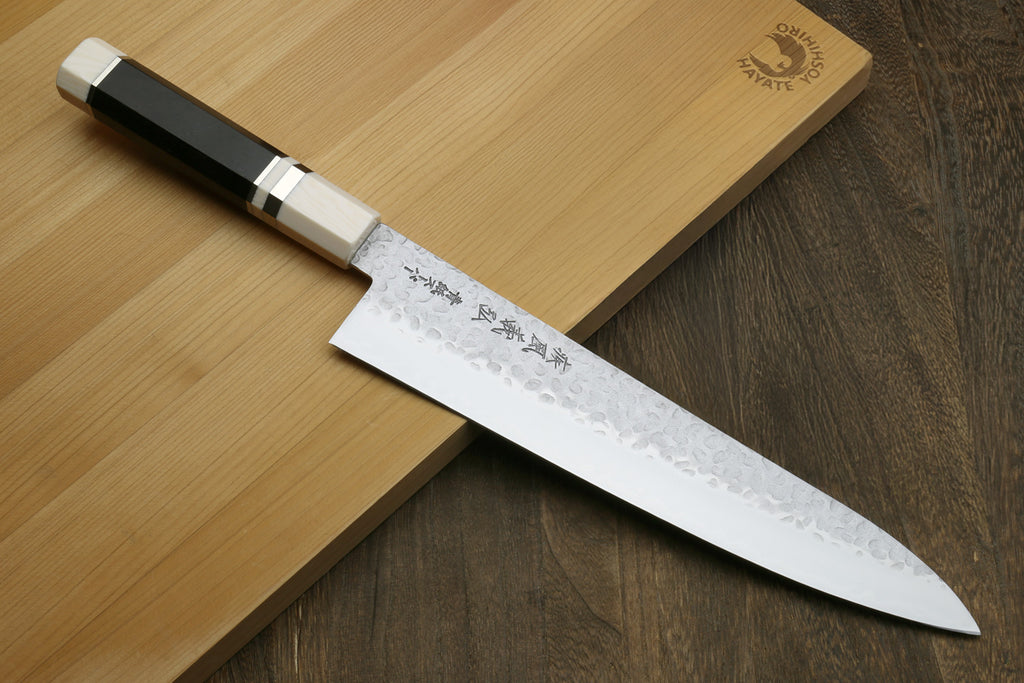 Hammered gyuto chef's knife with white patterned blade and off-white handle bolster