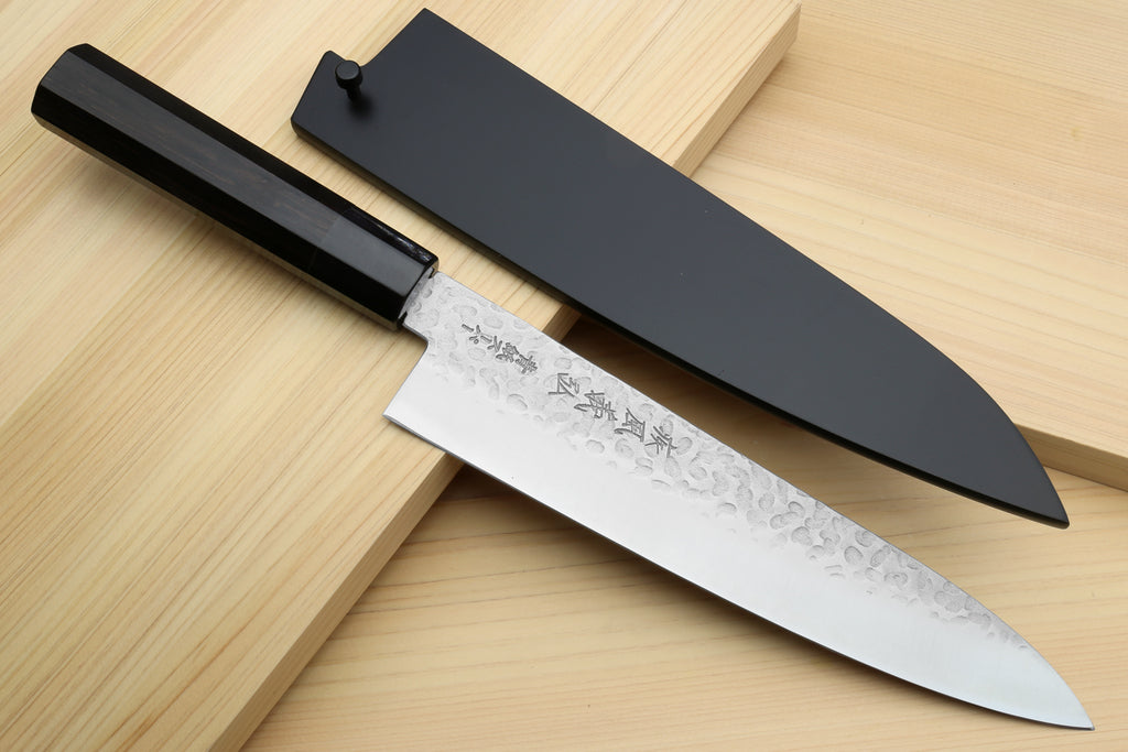 Hammered stainless gyuto chef's knife with ebony handle and dark sheath