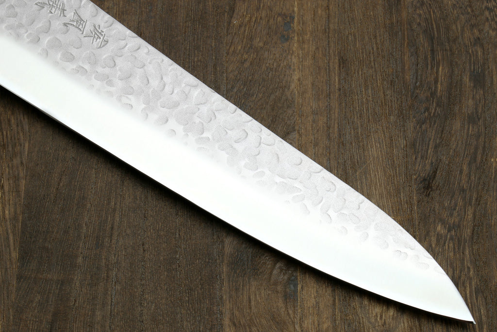 Gyuto chef knife blade edge close-up with hammered texture and pointed tip