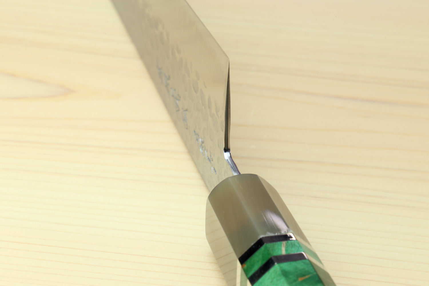 Gyuto chef knife spine near handle with engraved markings and rivet